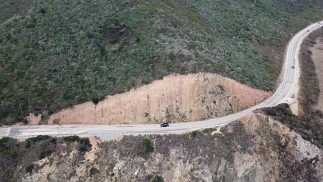 Car-drives-on-scenic-road-leading-to-Bixby-Creek-bridge,-California