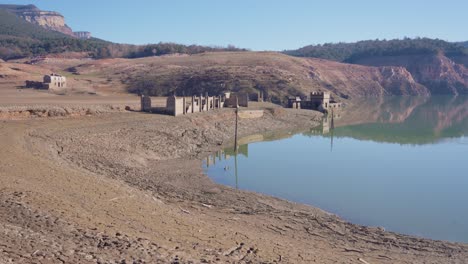 old buildings emerging from empty swamp due to the problems of extreme dryness and lack of rain