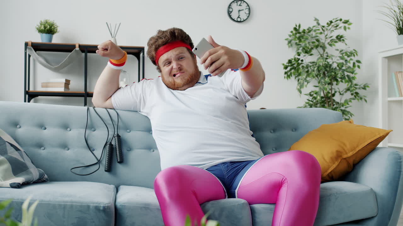 Funny friends taking selfies while working out on sofa