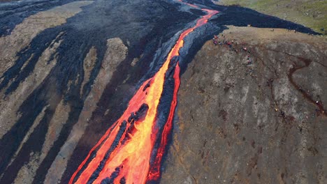 río de lava que fluye por un acantilado durante la erupción de fagradalsfjall en islandia - toma aérea de drones
