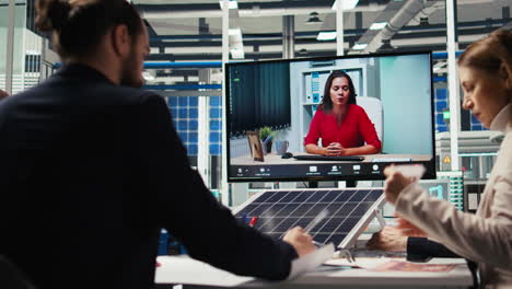 investors in office reviewing solar technology reports during videocall meeting