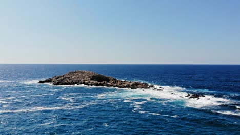 waves crashing up against the rocks in the middle of the ocean in jerusalem beach, erisos, greece - aerial drone shot