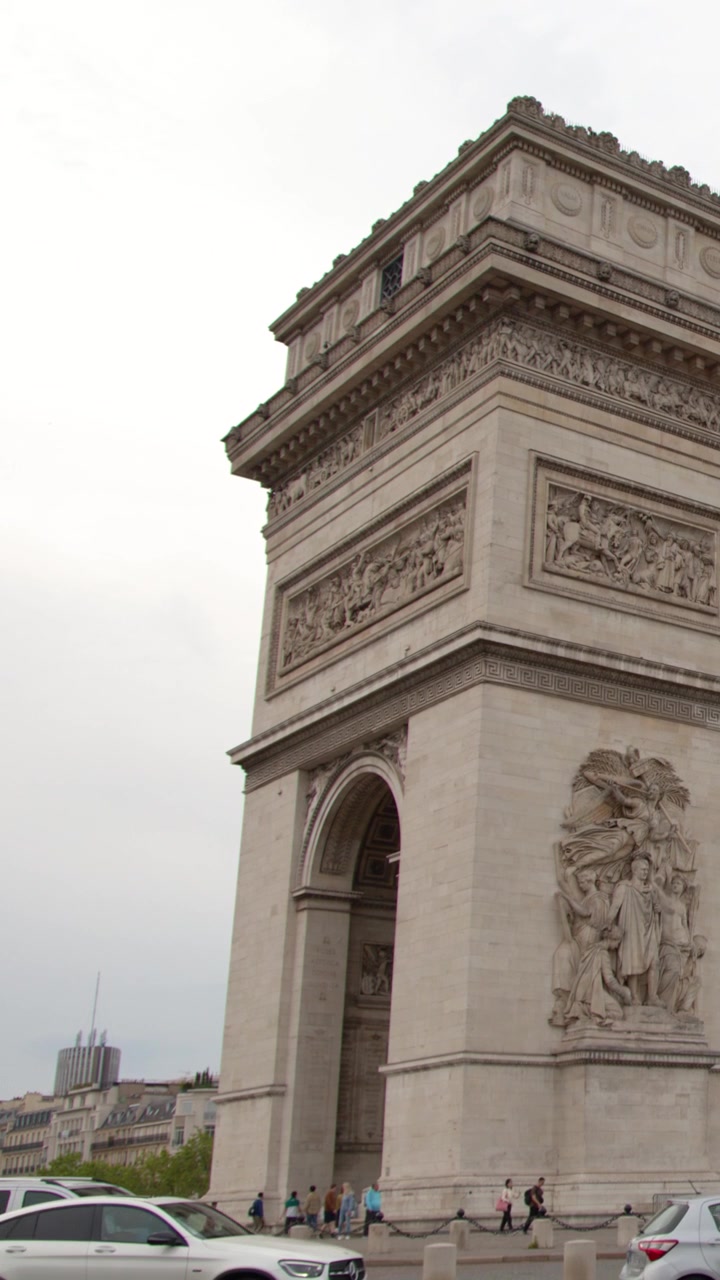 Vista dal basso dell'Arco di Trionfo con auto che passano a Parigi, Francia
