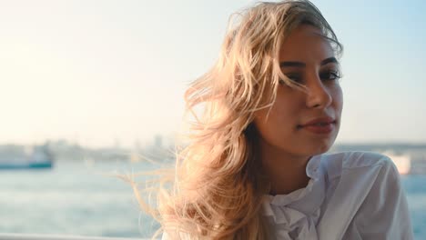 slow motion:beautiful girl enjoys moment while cruising with view of sea on background