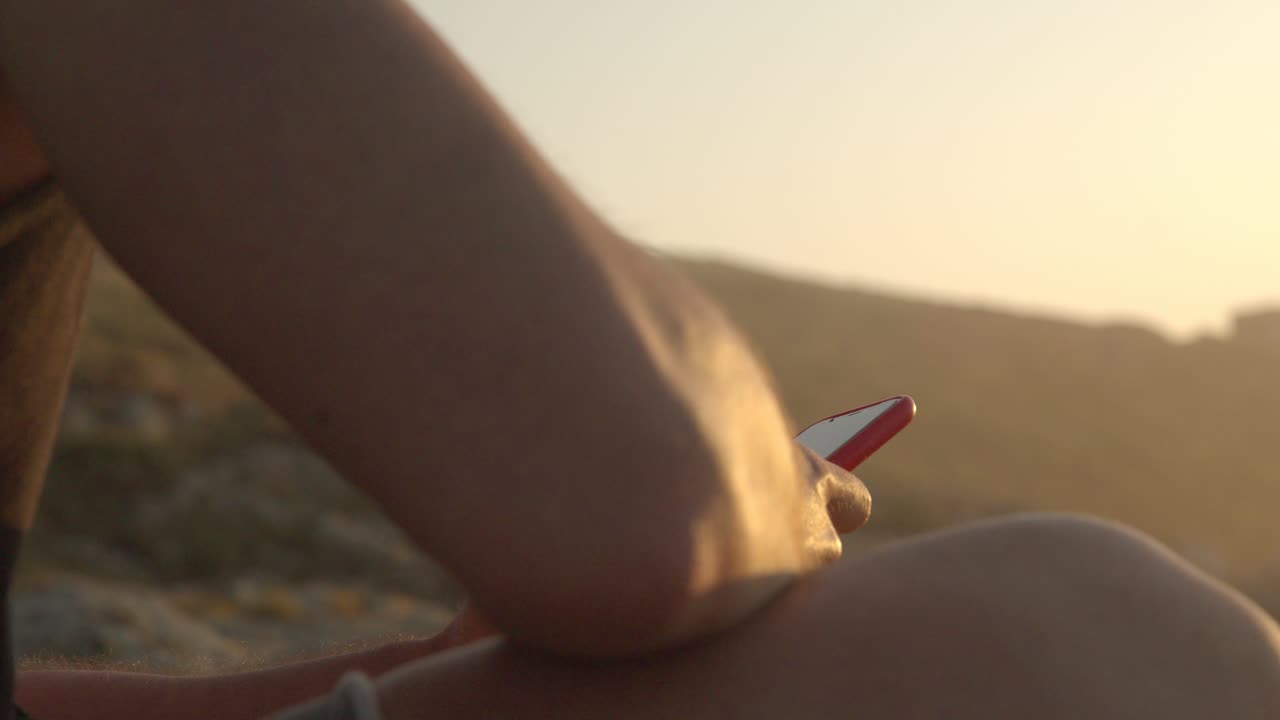 해변 에 앉아 스마트폰 을 검색 하는 사람