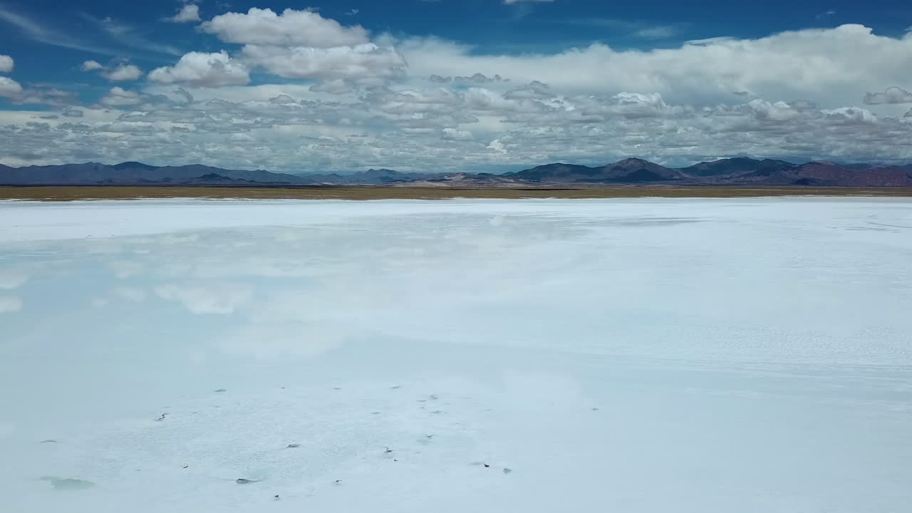 Aerial View of Salt Flat Lake With Sky Mirror Reflection and Colorful Hills on Skyline. Salinas Grandes, Salta, Argentina