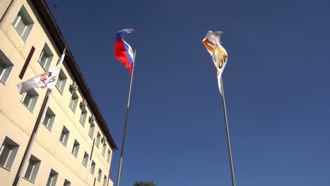 flags of russia flying outside a building