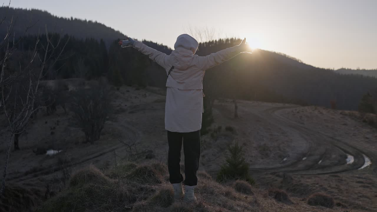 Woman enjoying the sunset in the mountains