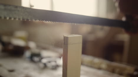 man producing wooden product indoors. guy sawing wooden plank in carpentry