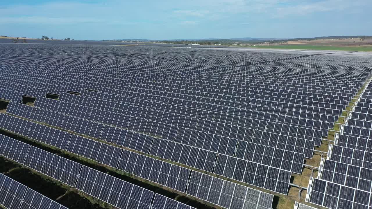 Droneoptagelse af en solcellepark, flyvende over et felt af solpaneler, optaget om eftermiddagen, i Warwick, Queensland, Australien, i 4K.