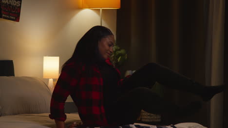 woman relaxing in her bedroom at night