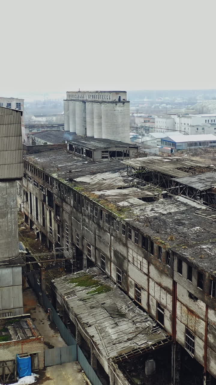 Aerial view of an old factory ruin and broken windows. Old industrial building for demolition. Vertical video