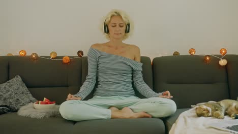 woman meditating on a sofa