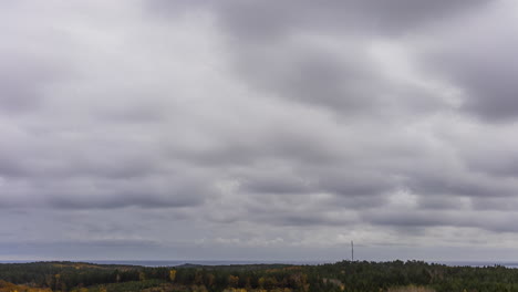 Thick-Storm-Clouds-in-Sky-Drift-Over-Woodlands-Below,-Cloudscape-Timelapse