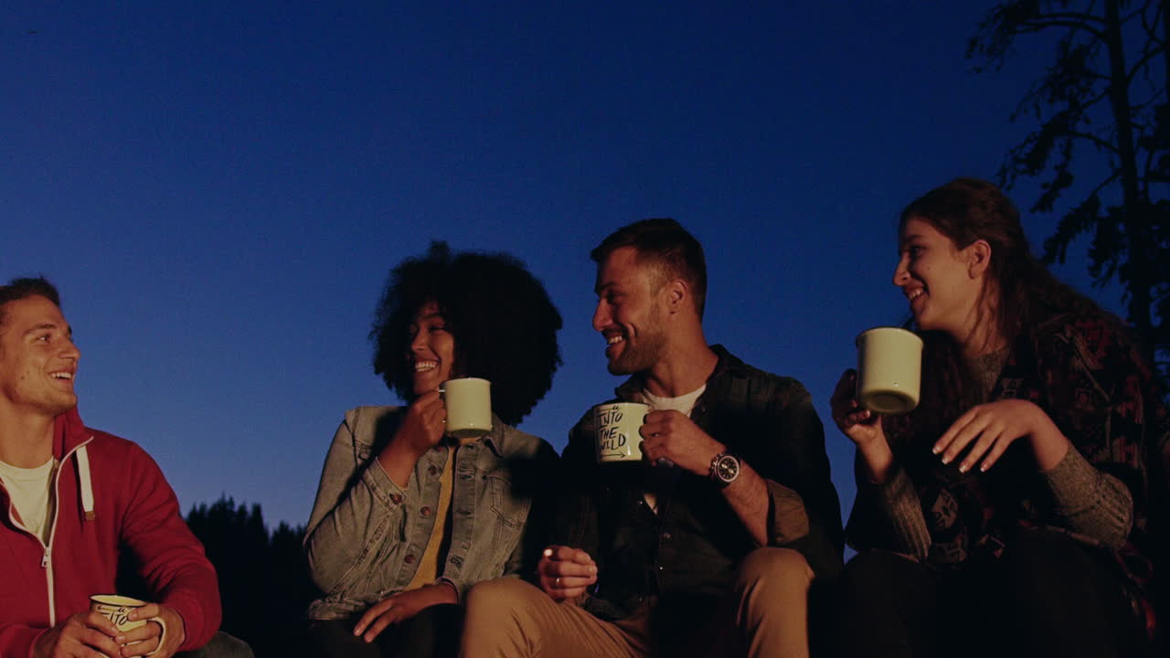 Friends Enjoying Campfire Drinks Under