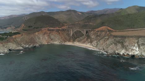 Luftbrummen-Stockvideo-Von-Bixby-Bridge-Highway-Mit-Wasser-Und-Ufer-Unten-In-Big-Sur-Monterrey-Kalifornien