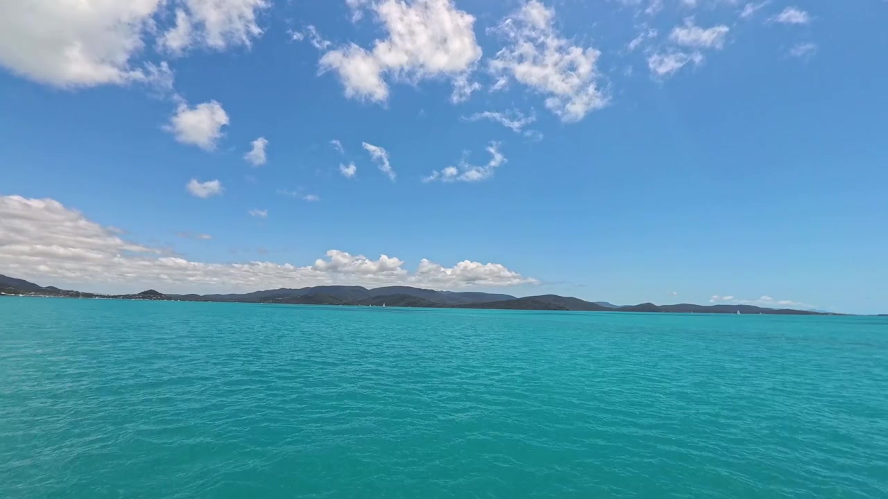 Vista panoramica sull'oceano turchese con cielo azzurro e isole lontane