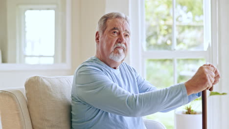 Senior-man,-walking-stick-and-thinking-in-home