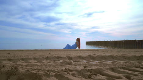 Woman-relaxing-beach.-Beautiful-woman-lying-on-sea-beach.-Woman-in-blue-dress