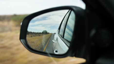 un espejo retrovisor a través del cual se puede ver la carretera y los alrededores