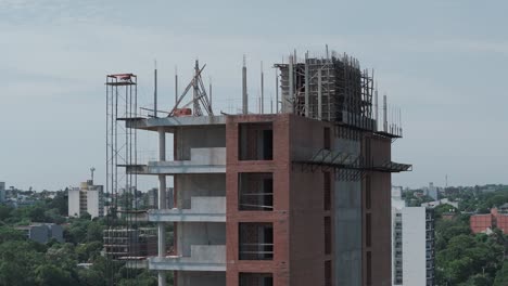 Experience-the-dynamic-construction-scene-from-a-bird's-eye-view-as-drone-footage-captures-the-building's-top-floors