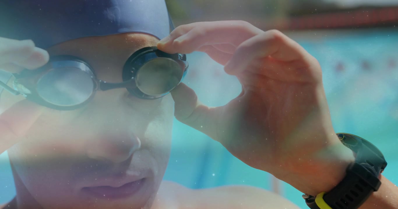 Swimmer wearing cap bringing hand to goggles and adjusting straps near bright lanes preparing swim