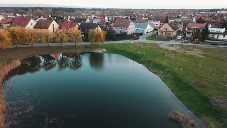 autumnal trees near small pond and beautiful houses in south moravian region, czech republic