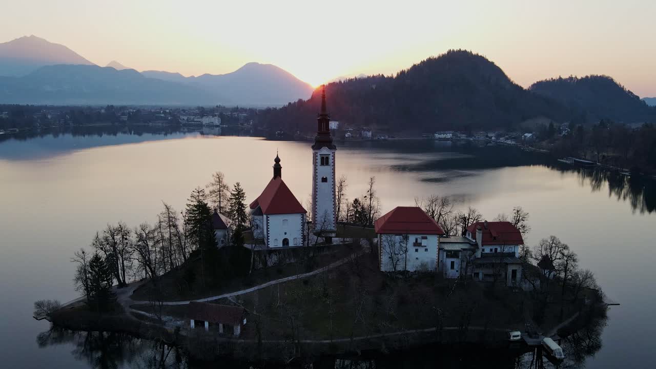 Lake Bled at sunrise, revealing the iconic island church in golden light, spring