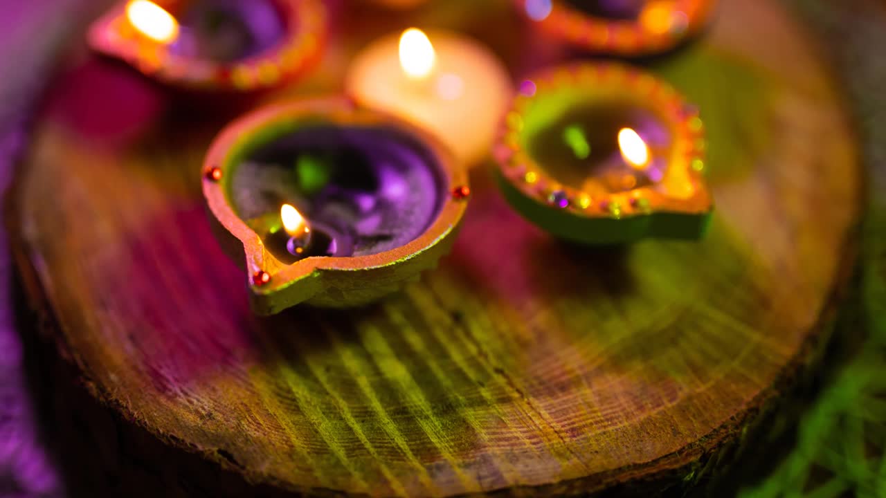 Video of glowing lit diwali candles in circle on wooden surface