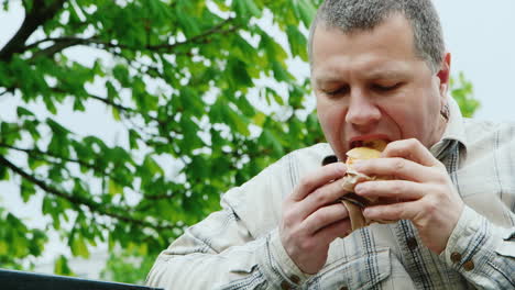 Brutaler-Mann-Mittleren-Alters,-Der-Draußen-Fast-Food-Isst