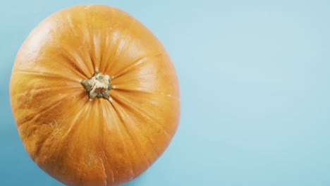 Overhead-close-up-view-of-halloween-pumpkin-against-blue-background