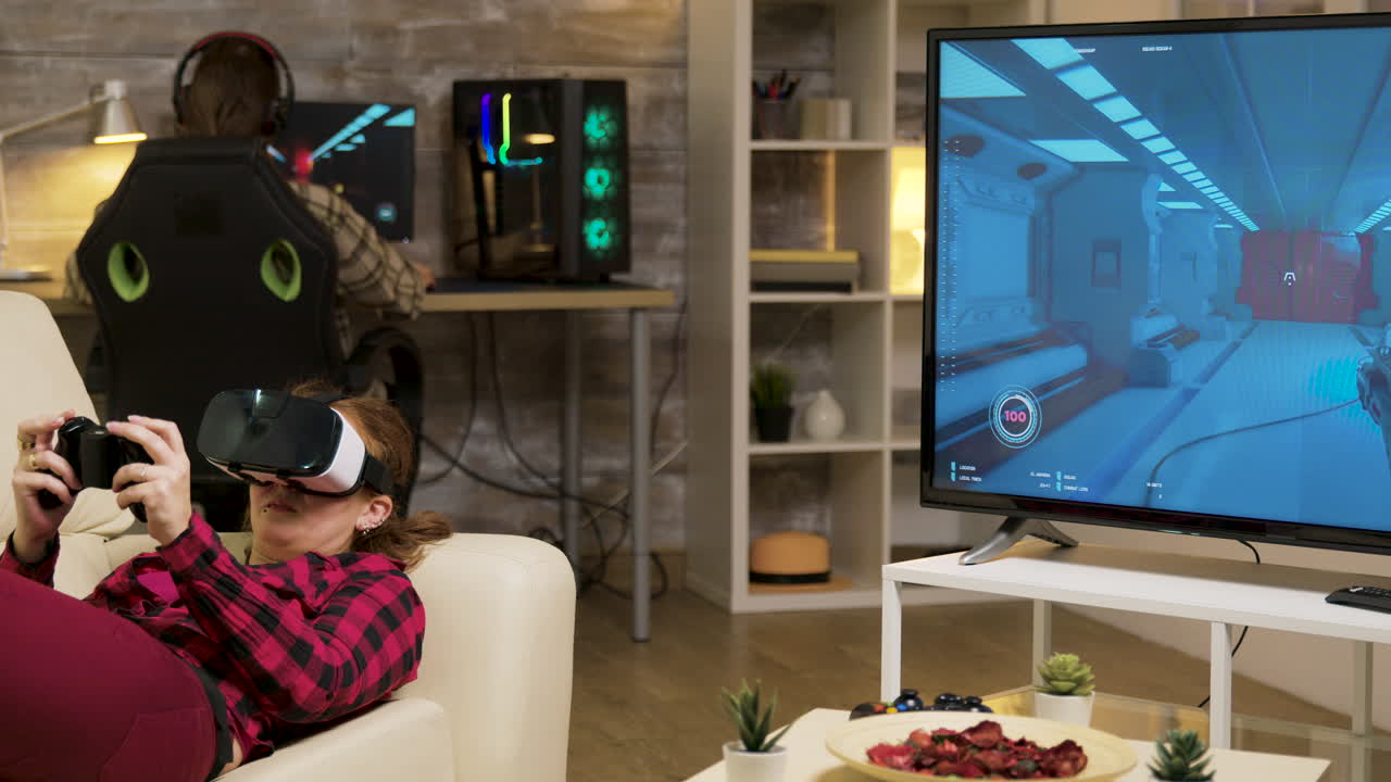 Woman playing VR games in the living room with a man playing on his computer