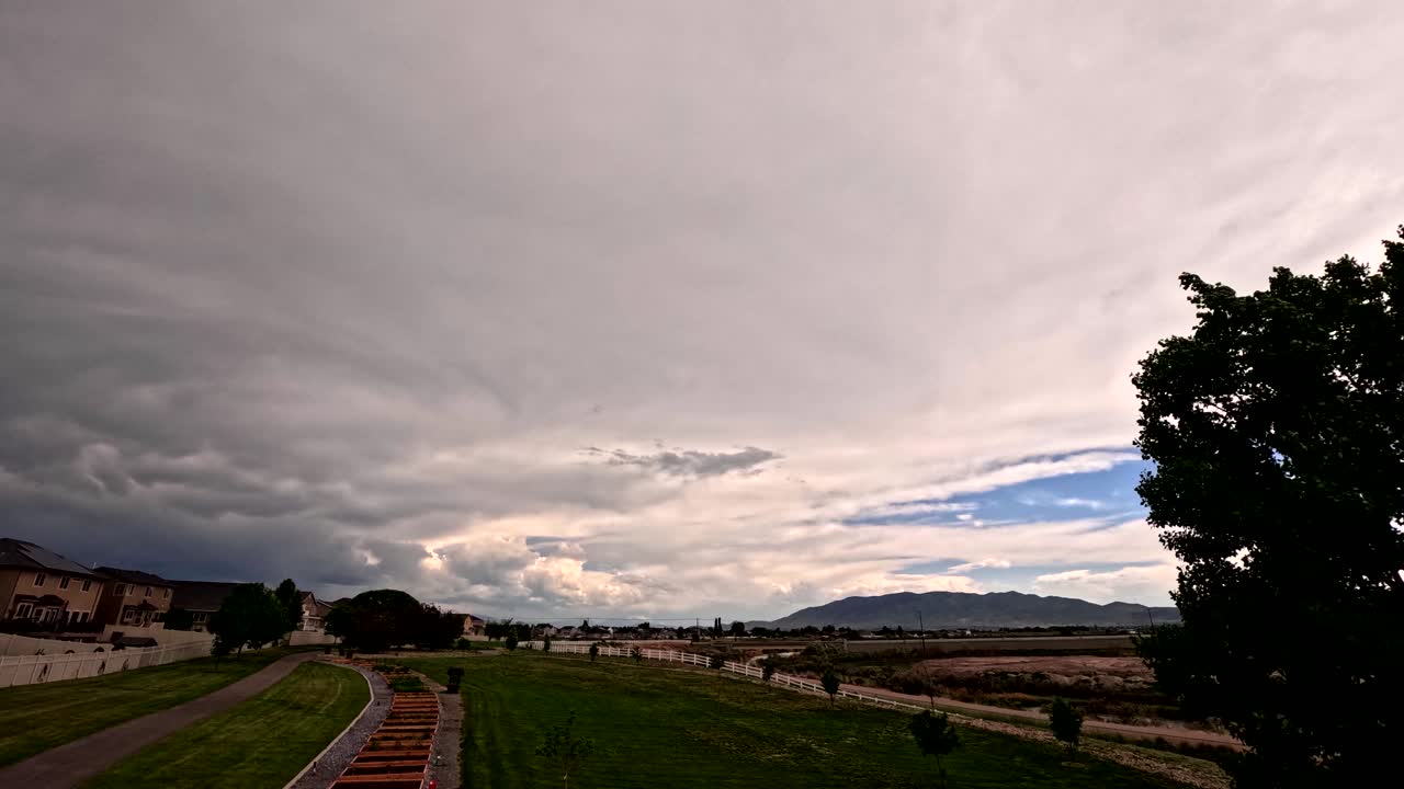 día nublado con una tormenta de lluvia soplando sobre un vecindario suburbano - lapso de tiempo