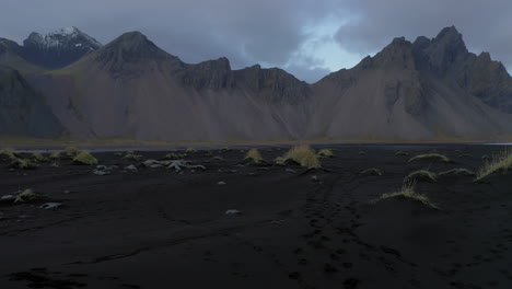 aerial: fly through the grass hills in stokksnes iceland during dusk
