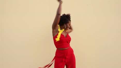 happy african american woman dancing near white wall