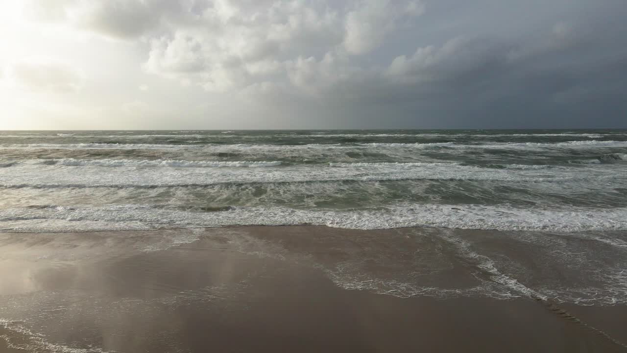 중간 고도 드론 은 왼쪽에서 오른쪽으로 으로 움직여 바다 파도와 hvide sande의 해변의 일부를 포착하여 격동의 바다와 극적인 해안 장면을 강조합니다.