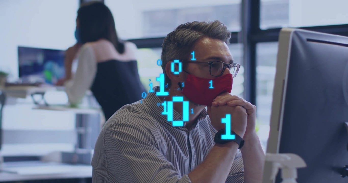 Seated man red mask glasses reacting to binary overlay in office clasping hands analyzing tech data