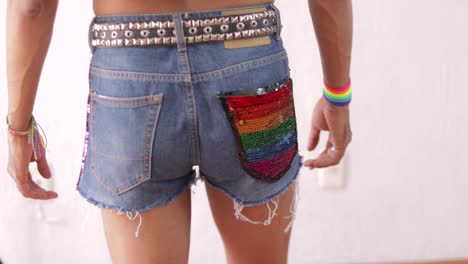 joven posando con coloridos detalles de arco iris en el tema lgbtq, mostrando el traje de orgullo