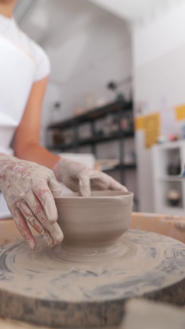 manos moldeando arcilla en una rueda de cerámica