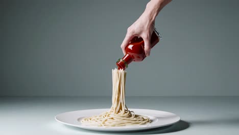 pouring tomato sauce over spaghetti