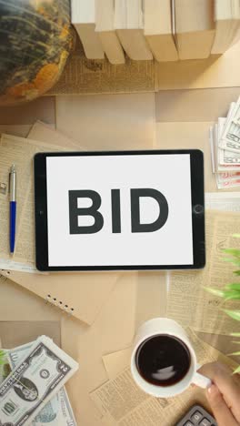 vertical video of bid displaying on finance tablet screen