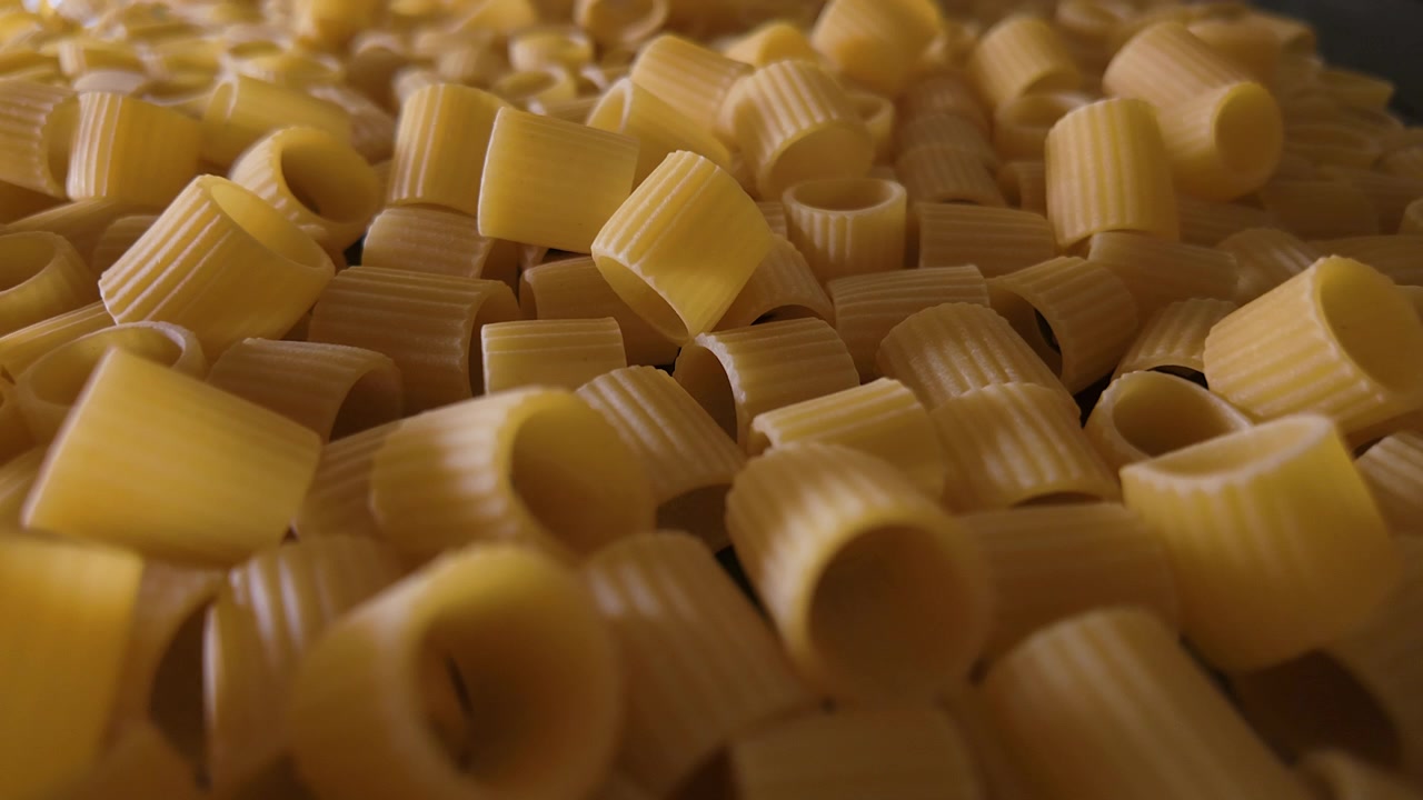 Ripresa macro con slider in POV a 50p attraverso pasta mezze maniche cruda.