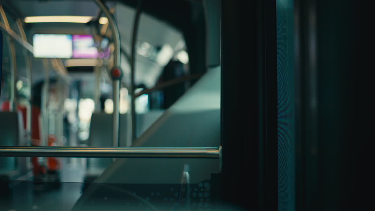 Interno di un autobus moderno con illuminazione soffusa e messa a fuoco ridotta, che crea un'atmosfera calma di pendolarismo urbano con profondità e composizione minimalista.