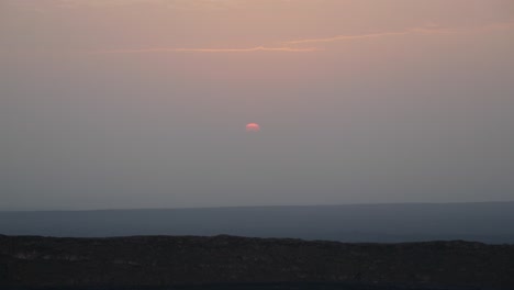 toma de paisaje de un sol cubierto de nubes, elevándose desde el cielo