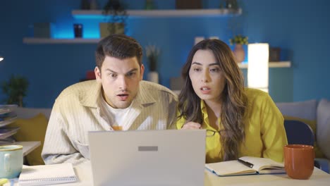 la pareja casada que se centra en la pantalla del portátil se sorprende por lo que ven.