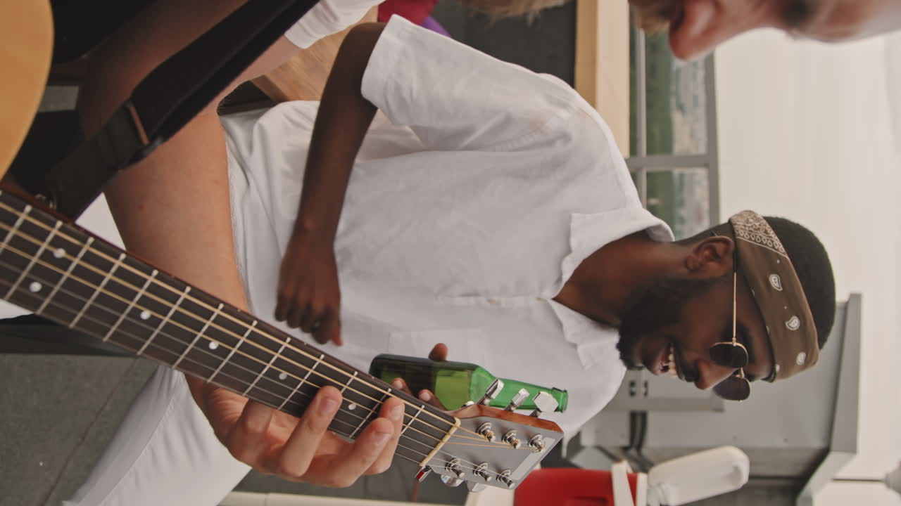 Man Playing Guitar and Friend Enjoying Music at Party