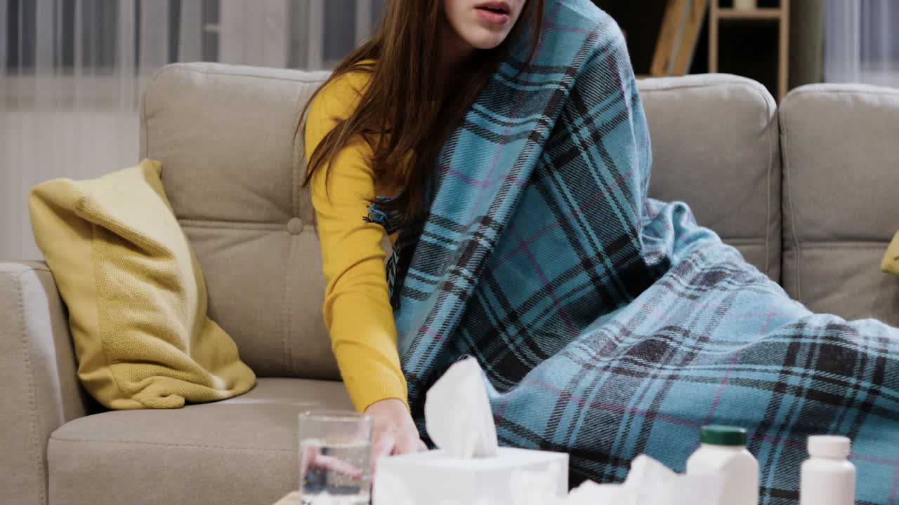 지친 여성이 스마트폰을 사용하고 기침하고 있습니다.