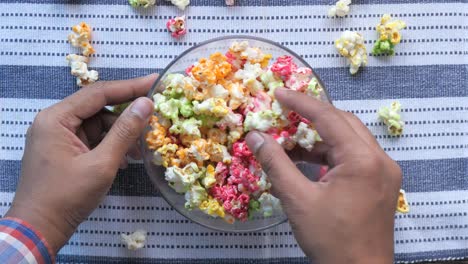 persona sosteniendo un tazón de palomitas de maíz coloridas