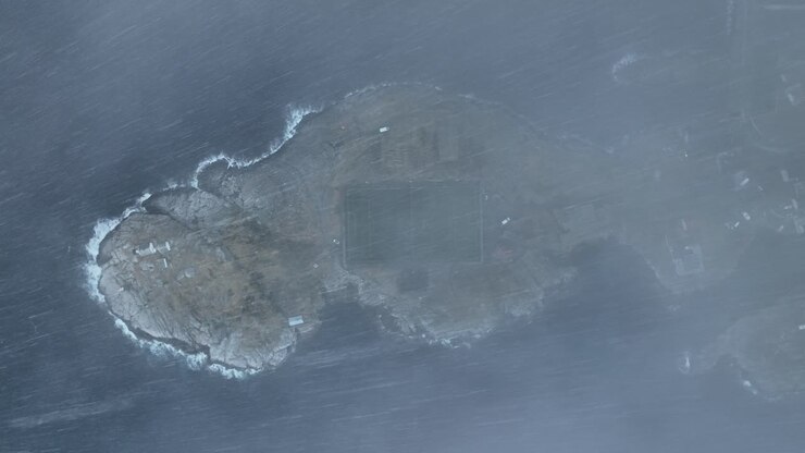 Stormy descending drone shot of Norway Lofoten Football Field Stadium in Henningsvaer