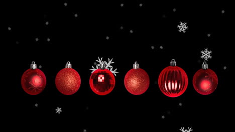 animación de copos de nieve cayendo sobre las bolas de navidad sobre fondo negro